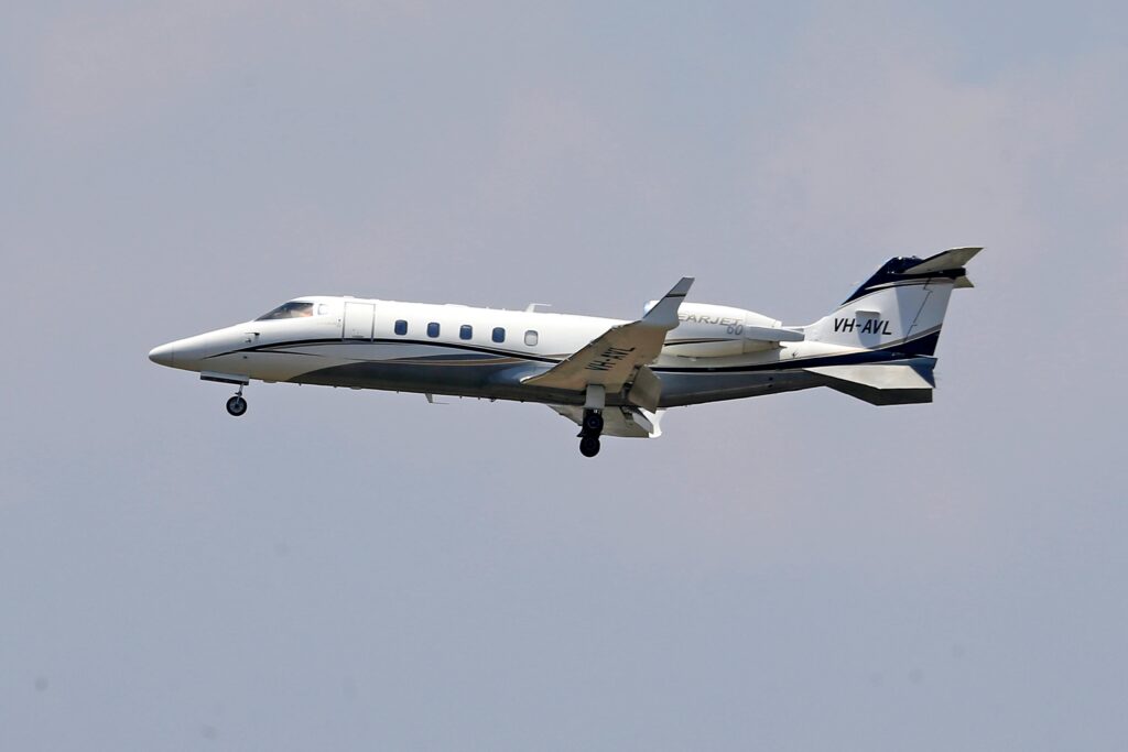 A Learjet 60 business jet captured flying through the clear sky.
